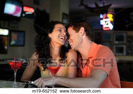 Couple enjoying cocktails at a bar View Large Photo Image Stock Image - Couple enjoying cocktails at a bar. Fotosearch