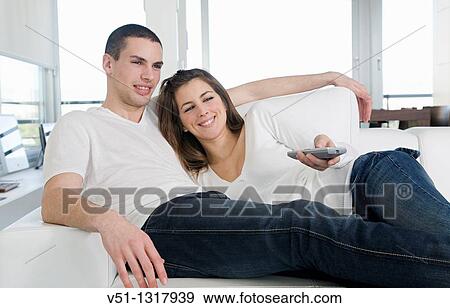 Couple enjoying leisure at home watching TV View Large Photo Image Stock Photo - Couple enjoying leisure at home watching TV. Fotosearch