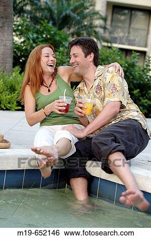 Couple enjoying poolside drinks View Large Photo Image Stock Photograph - Couple enjoying poolside drinks. Fotosearch