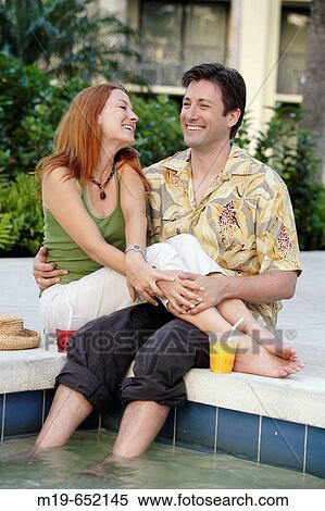 Couple enjoying poolside together View Large Photo Image Stock Photography - Couple enjoying poolside together. Fotosearch