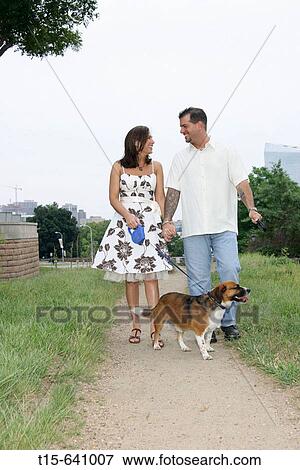 Stock Photo - Couple enjoying taking a walk with their dog. Fotosearch