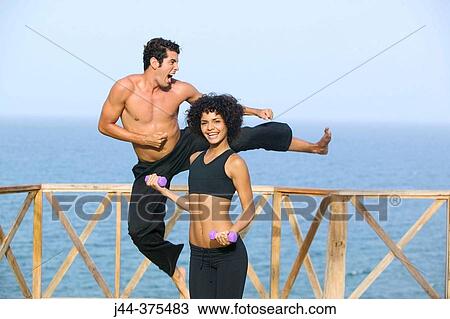 Stock Image - Couple exercising by the ocean. Fotosearch