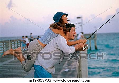 Couple fishing and laughing on a pier View Large Photo Image Stock Image - Couple fishing and laughing on a pier. Fotosearch