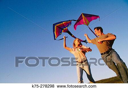 Couple flying a kit View Large Photo Image Stock Photo - Couple flying a kit. Fotosearch