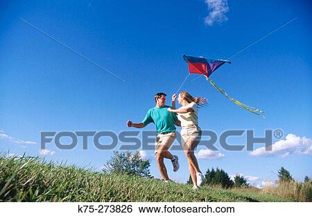 Stock Photograph - Couple flying a kite. Fotosearch