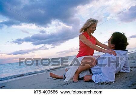 Couple getting romantic on the beach View Large Photo Image Stock Photograph - Couple getting romantic on the beach. Fotosearch