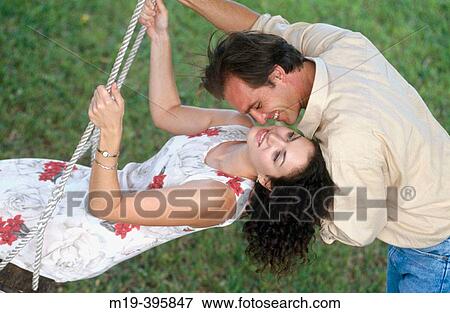 couple- girl is on a swing View Large Photo Image Stock Photo - couple- girl is on a swing. Fotosearch