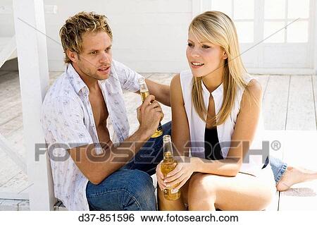 Couple having a beer at home View Large Photo Image Stock Photograph - Couple having a beer at home. Fotosearch