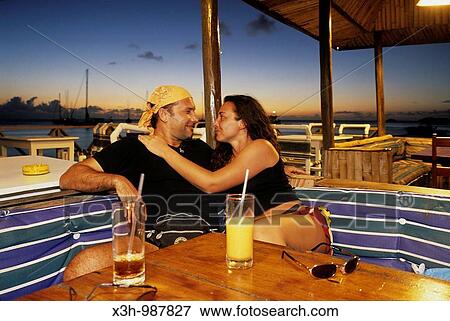 Stock Photo - couple having a drink at Basil's bar, Mustik, Grenadines islands, Saint Vincent and the Grenadines, Winward Islands, Lesser Antilles, Caribbean Sea. Fotosearch