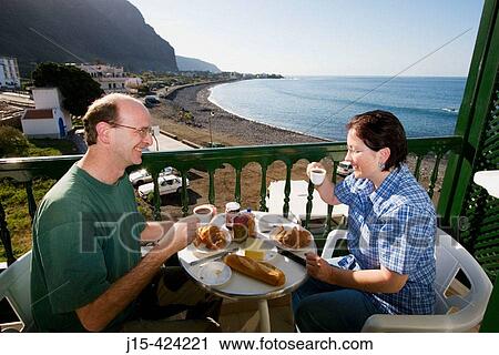 Couple having breakfast on balcony. Valle Gran Rey. La Gomera. Canary Islands. Spain. View Large Photo Image Stock Image - Couple having breakfast on balcony. Valle Gran Rey. La Gomera. Canary Islands. Spain.. Fotosearch