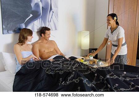 Stock Photo - couple having breakfast served on bed. Fotosearch