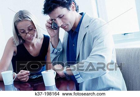 Couple having coffee & checking time & info on PDA View Large Photo Image Picture - Couple having coffee & checking time & info on PDA. Fotosearch