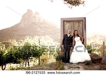 couple holding hands in front of a rustic door with vineyards and scenic mountains View Large Photo Image Stock Image - couple holding hands in front of a rustic door with vineyards and scenic mountains. Fotosearch