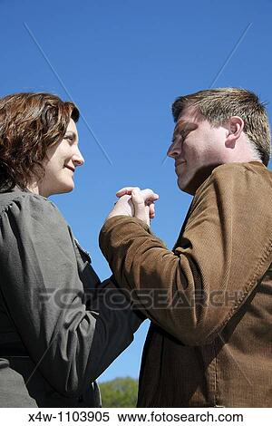 Couple holding hands on a sunny day in a park View Large Photo Image Stock Photography - Couple holding hands on a sunny day in a park. Fotosearch