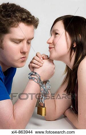 Couple holding hands with chain linking them View Large Photo Image Picture - Couple holding hands with chain linking them. Fotosearch
