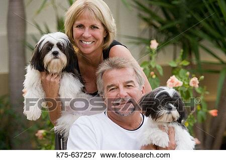 Couple holding their pet dogs View Large Photo Image Stock Photo - Couple holding their pet dogs. Fotosearch