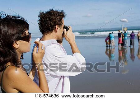 couple holidaying and taking snapshot on beach View Large Photo Image Stock Photograph - couple holidaying and taking snapshot on beach. Fotosearch