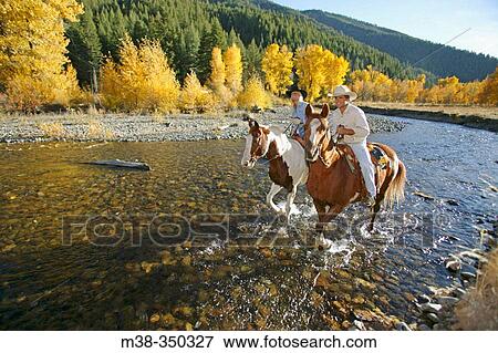 Stock Photo - Couple horseback riding near Sun Valley, Idaho. USA. Fotosearch