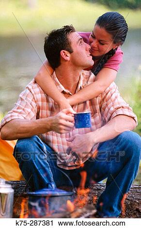 Stock Image - couple hugging at campsite. Fotosearch