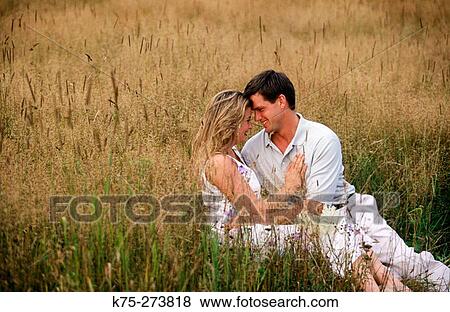 Stock Photo - Couple hugging in a field. Fotosearch