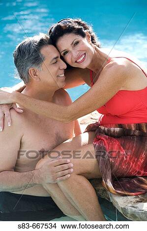 Picture - Couple hugging in pool. Fotosearch