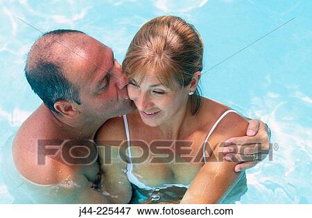 Stock Photo - Couple hugging in the pool. Fotosearch