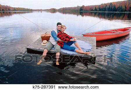 Stock Image - couple hugging on floating dock. Fotosearch