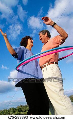 Stock Image - couple hula hooping. Fotosearch