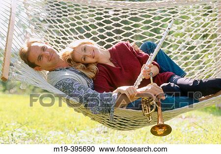 Stock Image - couple in a hammock, playing music. Fotosearch