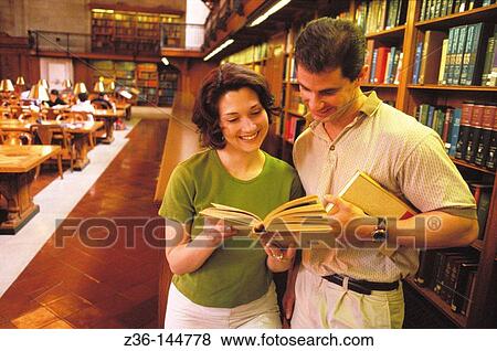 Couple in a library View Large Photo Image Stock Photo - Couple in a library. Fotosearch