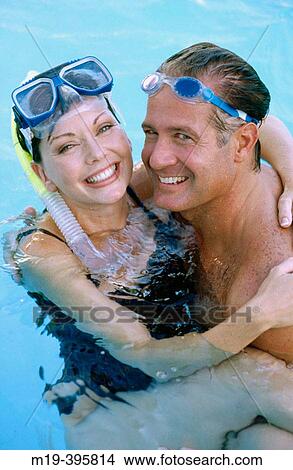 Picture - couple in a swiming pool with goggles. Fotosearch