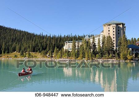 Stock Photo - Couple in canoe in front of the hotel Castle Lake Louise, Banff National Park, Rocky Mountains, Alberta, Canada. Fotosearch