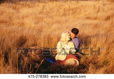 Stock Image - couple in field in the fall. Fotosearch