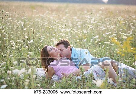 Couple in field of flowers View Large Photo Image Stock Photograph - Couple in field of flowers. Fotosearch