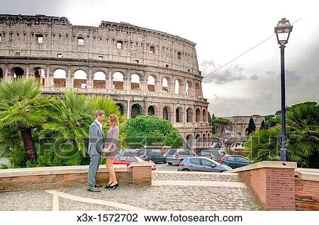 Stock Image - Couple in front of the Roman Colosseum. Fotosearch