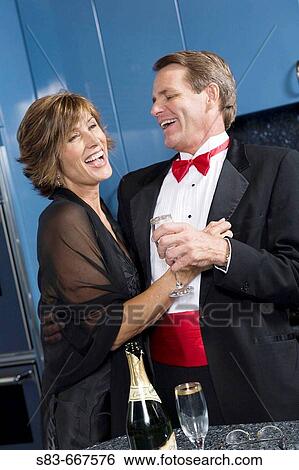 Couple in kitchen getting ready for a formal night out. View Large Photo Image Stock Photograph - Couple in kitchen getting ready for a formal night out.. Fotosearch