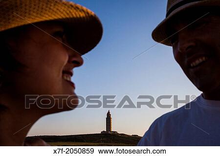 Stock Photo - Couple in Punta Herminia gardens, in background Tower of Hercules, Roman lighthouse, Corua city, Galicia, Spain.. Fotosearch