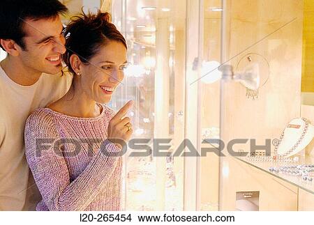 Couple in shopping center, looking at jewelry View Large Photo Image Picture - Couple in shopping center, looking at jewelry. Fotosearch