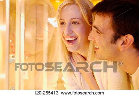 Couple in shopping center, looking at jewelry View Large Photo Image Stock Image - Couple in shopping center, looking at jewelry. Fotosearch
