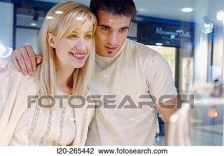 Stock Image - Couple in shopping center, looking at shop windows. Fotosearch