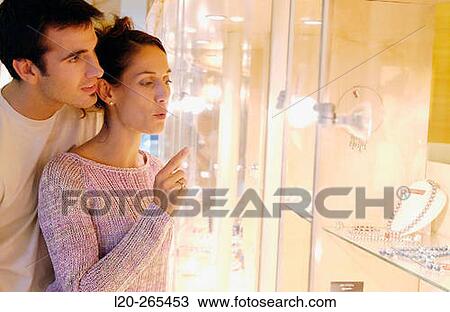 Couple in shopping center, looking at jewelry View Large Photo Image Stock Image - Couple in shopping center, looking at jewelry. Fotosearch