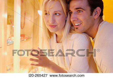 Stock Photo - Couple in shopping center, looking at jewelry. Fotosearch