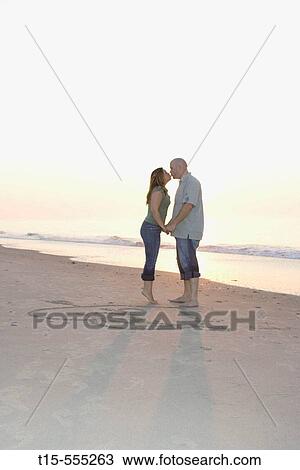 Couple in their 20's kissing on the beach of ocean city by the drawing of heart and arrow and their initials View Large Photo Image Stock Image - Couple in their 20's kissing on the beach of ocean city by the drawing of heart and arrow and their initials. Fotosearch