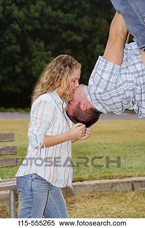 Couple in their 20's kissing with him hanging upside down View Large Photo Image Stock Photography - Couple in their 20's kissing with him hanging upside down. Fotosearch