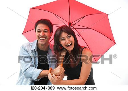 Couple in their 30's smiling under umbrella. View Large Photo Image Stock Photo - Couple in their 30's smiling under umbrella.. Fotosearch
