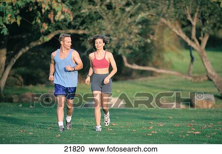 Stock Image - Couple jogging in park. Fotosearch
