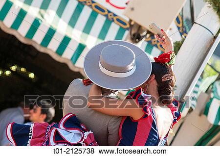 couple kissing and getting a photo with the phone in the April Fair of Seville. View Large Photo Image Stock Photo - couple kissing and getting a photo with the phone in the April Fair of Seville.. Fotosearch
