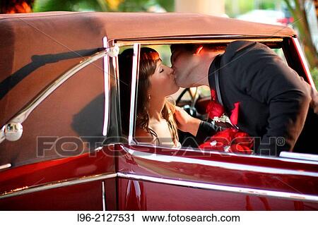 couple kissing before getting away in a classic car View Large Photo Image Stock Image - couple kissing before getting away in a classic car. Fotosearch
