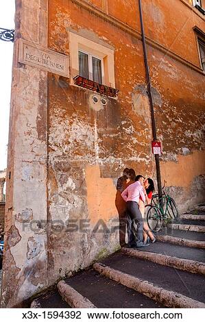 Stock Image - Couple kissing in a roman alleyway Rome Italy. Fotosearch