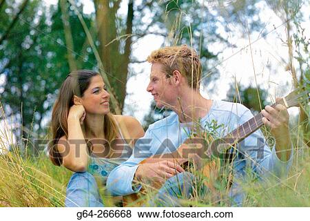 Couple listening to the guitar View Large Photo Image Stock Photo - Couple listening to the guitar. Fotosearch